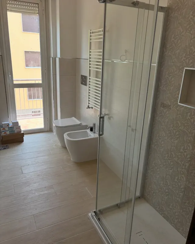 Bagno rifatto con box doccia in cristallo, sanitari sospesi e termoarredo